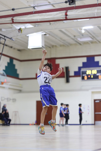 Photo of Elementary School Boy playing basketball in gym
