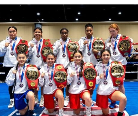 UCC Boxing Group holding championship belts and wearing medals