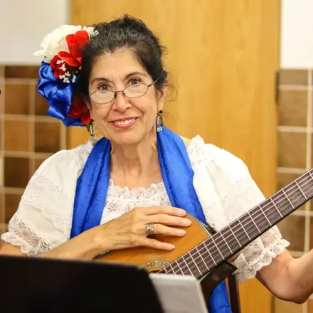 Senior lady playing the guitar and smiling