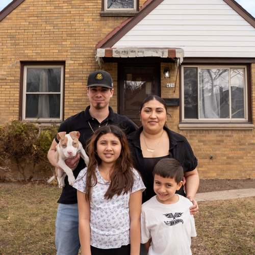 New home owners standing in front of their home