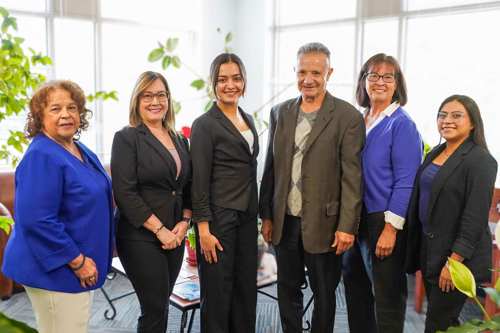 Neighborhood Development Team standing in the lobby of the office and smiling