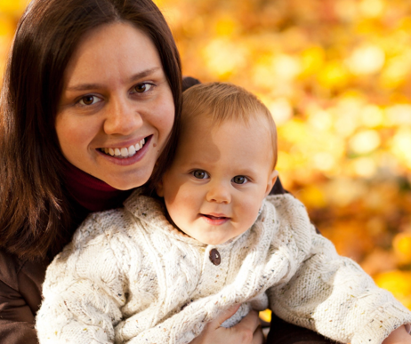 Photo of a mother with her infant baby outside on a sunny fall day
