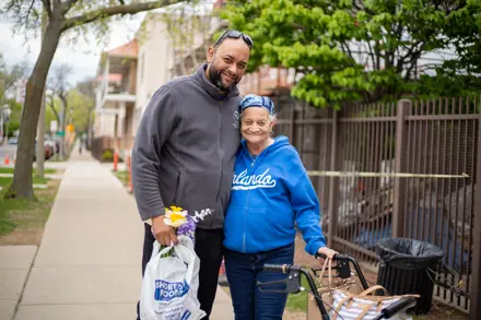 Adult Day Center client with caregiver standing in front and smiling