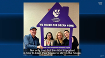A family holds a house shaped sign that reads, "We found our Dream home!"